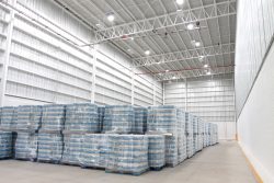 Piles de palettes emballées dans du plastique dans un grand entrepôt industriel